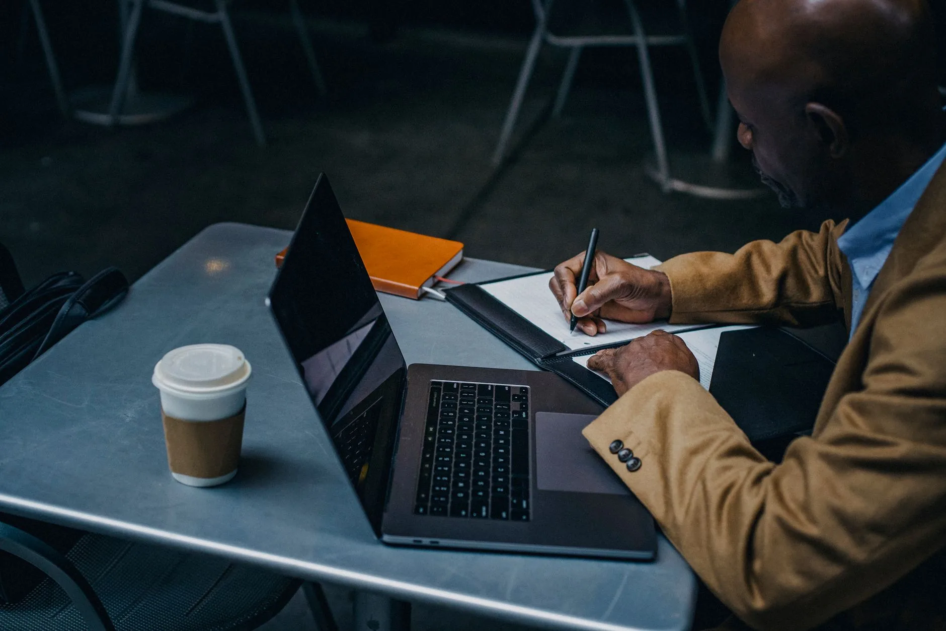 A person at a wooden desk in a cozy study, resolving short stories and essays.