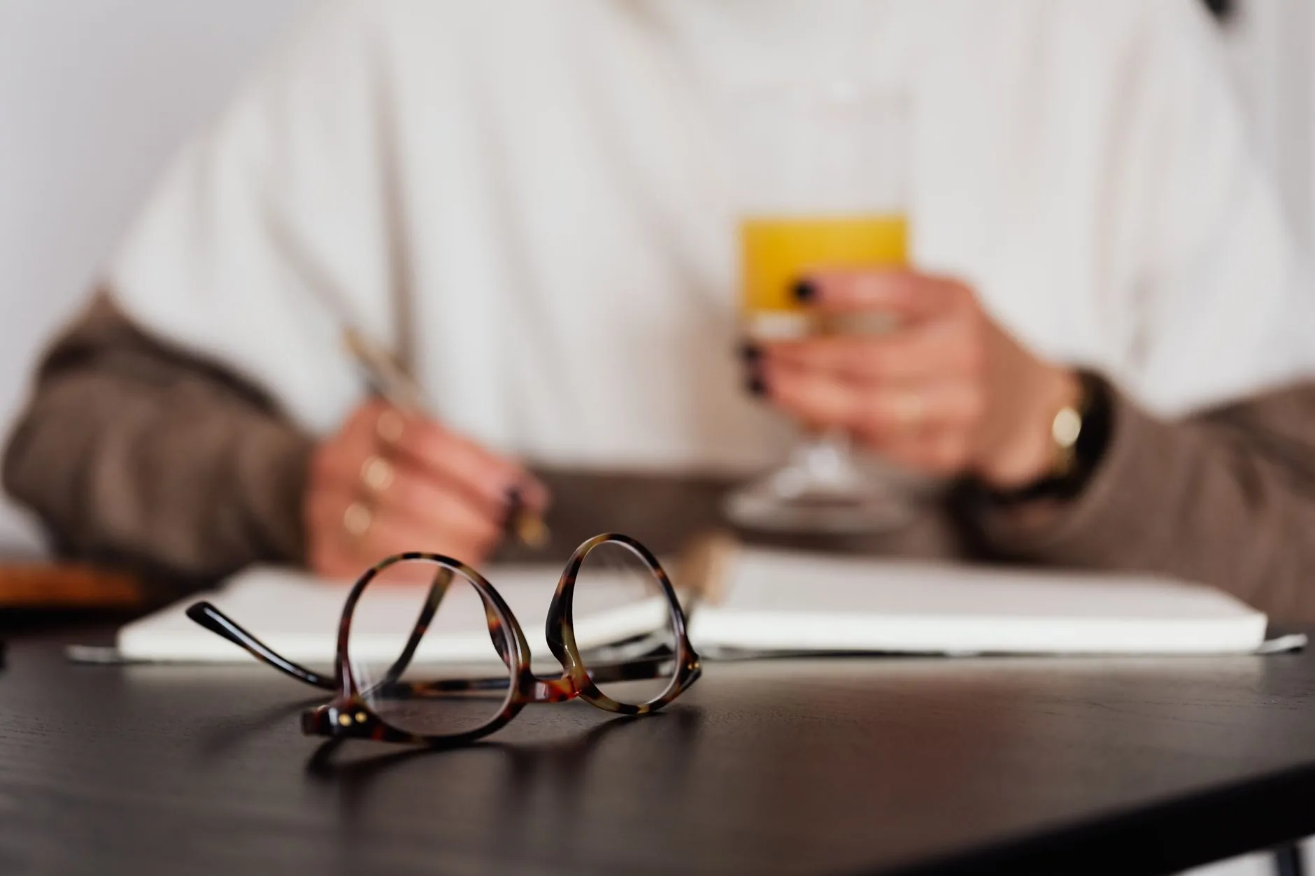 A writer pens at a vintage desk, surrounded by books and notes, crafting dialogue.