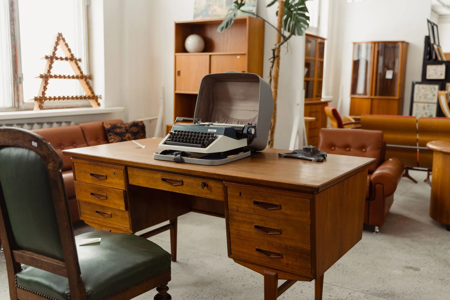 A cluttered writer's desk with papers and a vintage typewriter, illustrating irregular verbs in narrative writing.