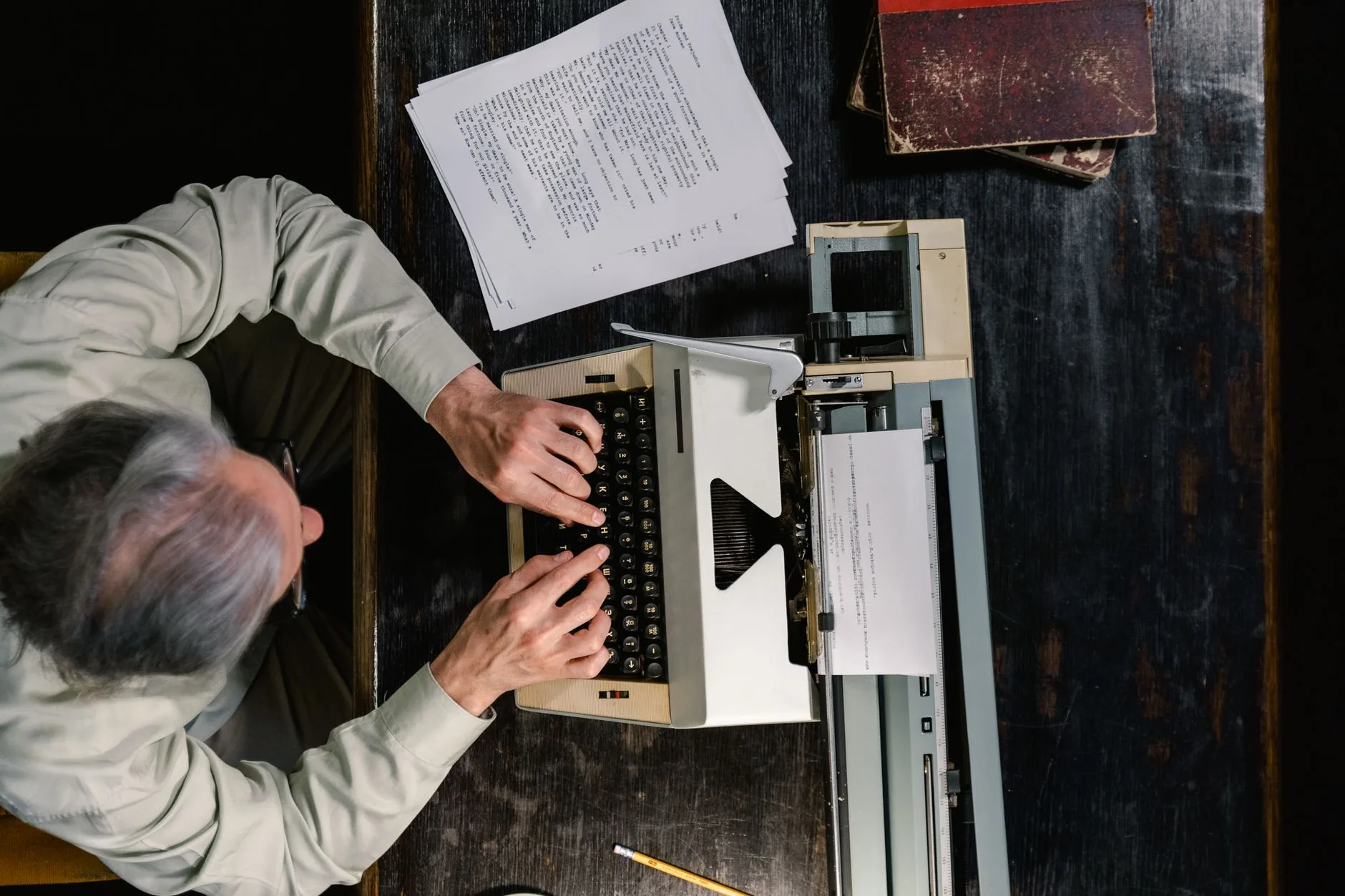 A cluttered writer's desk with a typewriter and scattered pages, muted colors, soft light.