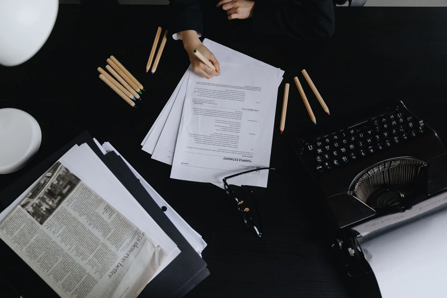 Writer's desk with scattered papers, notebooks, and a pen, muted colors, soft light.